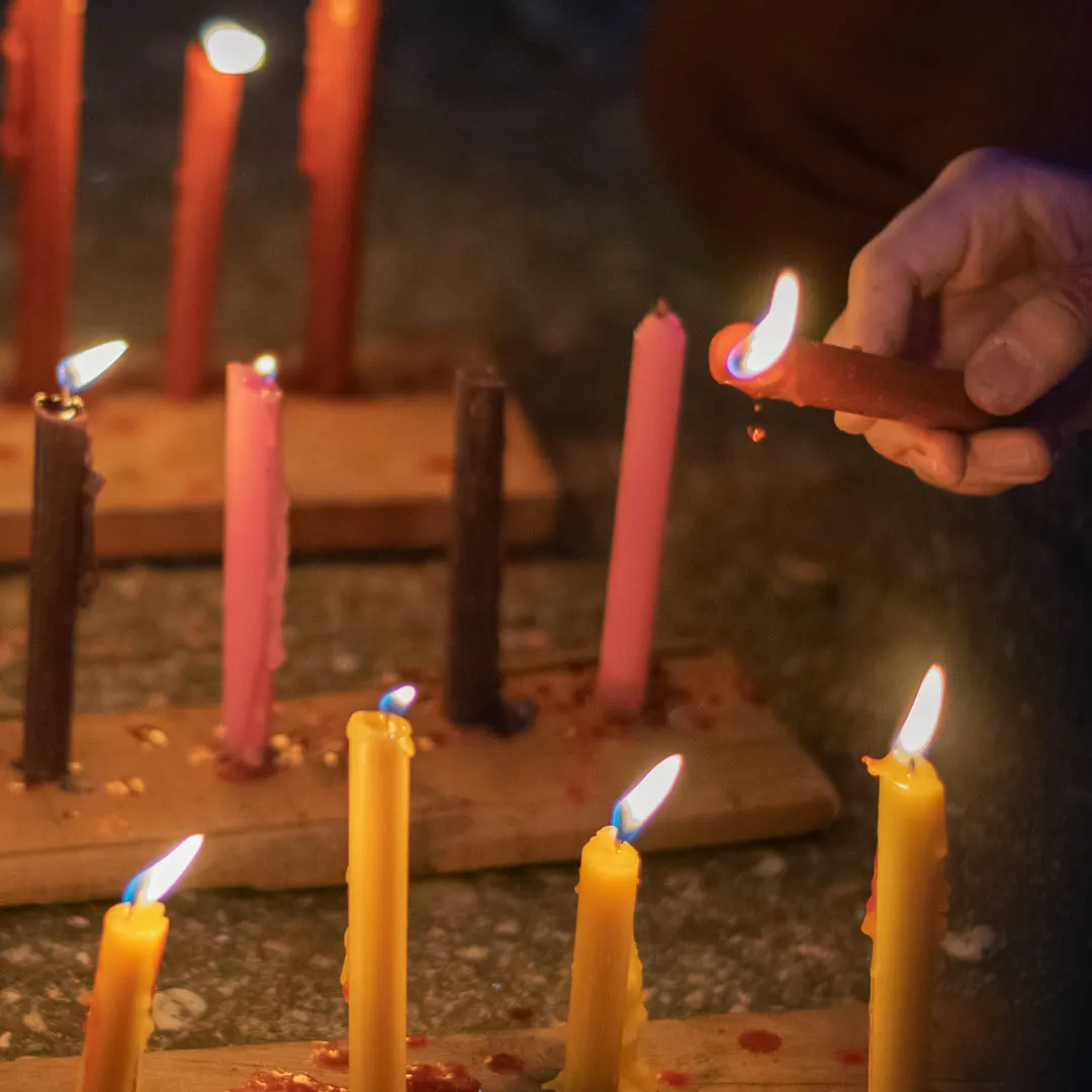 Velitas de colores encendidas en el suelo durante el Día de las Velitas en Colombia