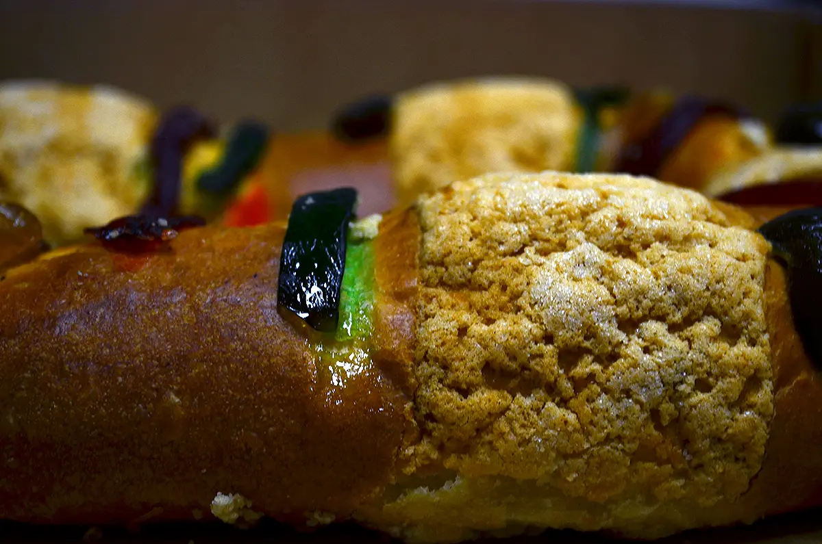 Close-up of a rosca de reyes with a sugar crust and strips of candied fruit
