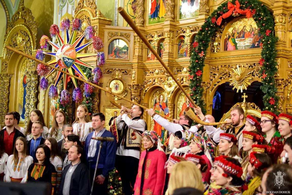 Колядники з різдвяною зіркою і духовими інструментами в церкві, прикрашеній гірляндою