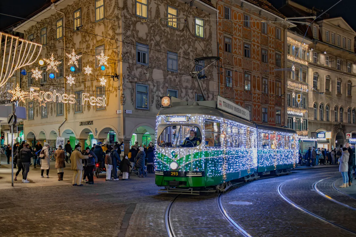 Mit Lichterketten geschmückte Straßenbahn und Sterne an der Grazer Herrengasse