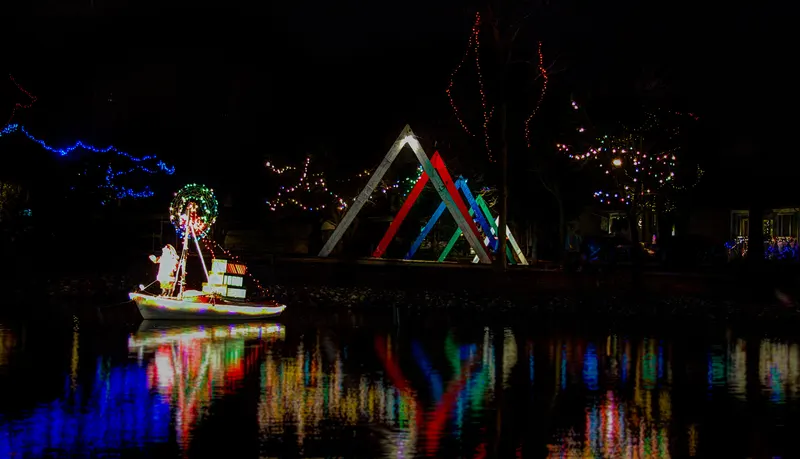 Boat and candy-coloured light displays by the water at the Simcoe Christmas Panorama