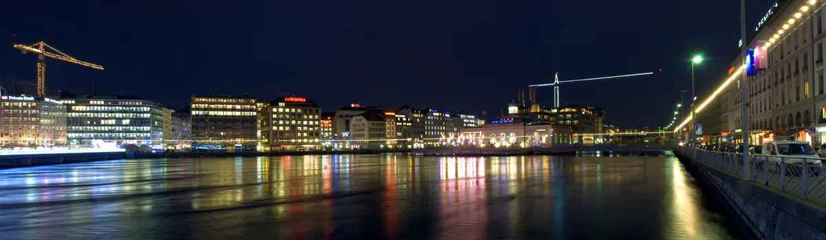 Lumières de Noël reflétées dans le Rhône vues depuis le quai des Bergues à Genève