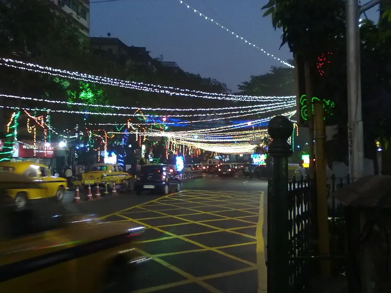 Yellow taxis under the festive light canopy on Park Street, Kolkata