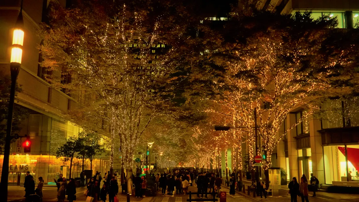 丸の内仲通りの街路樹を彩るシャンパンゴールドのイルミネーションと夜の散策客