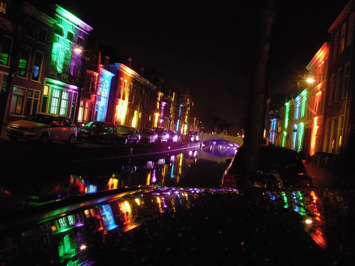 Verlichte gevels langs de gracht tijdens Lichtjesavond in Delft