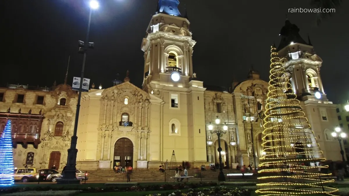 Catedral de Lima de noche con un árbol de luces doradas en la Plaza Mayor