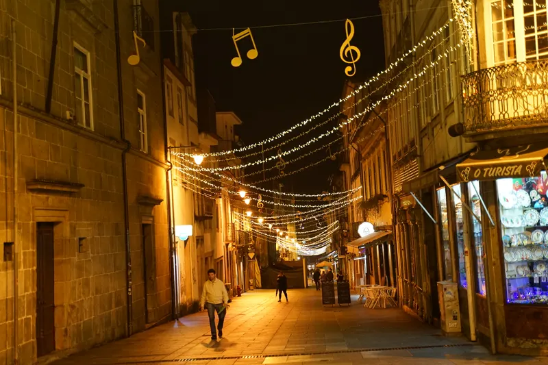 Rua do centro de Braga com luzes de Natal e notas musicais