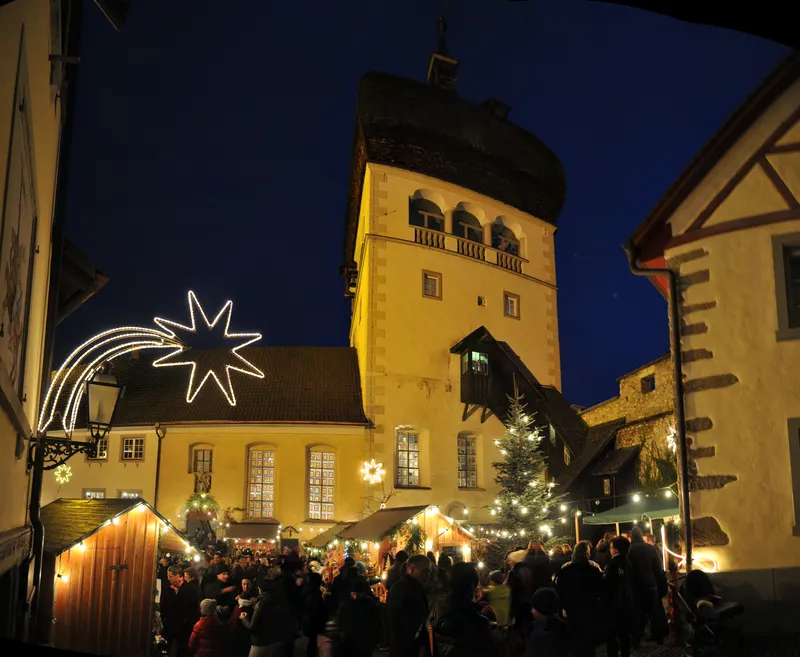 Martinsturm mit leuchtendem Stern über dem Weihnachtsmarkt der Bregenzer Oberstadt