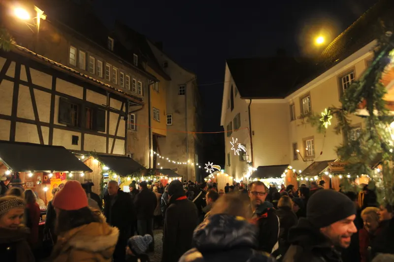 Besucher und Lichterketten auf dem Weihnachtsmarkt in der Oberstadt von Bregenz