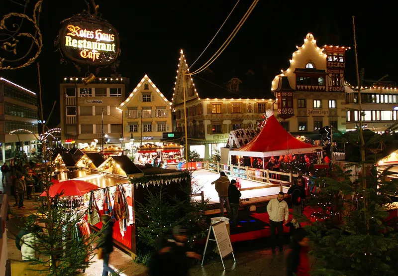 Beleuchtete Hütten und Giebelhäuser auf dem Dornbirner Christkindlemarkt bei Nacht