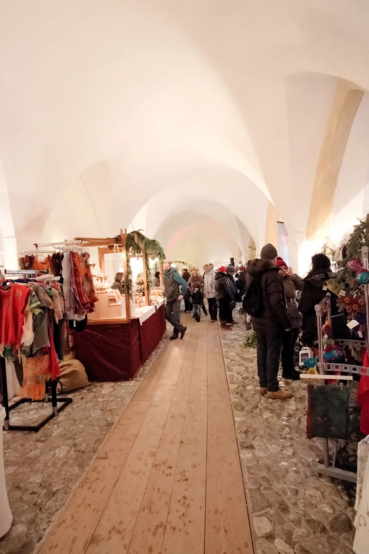 Adventmarkt im gewölbten Saal des Klosters Mondsee mit Kunsthandwerksständen