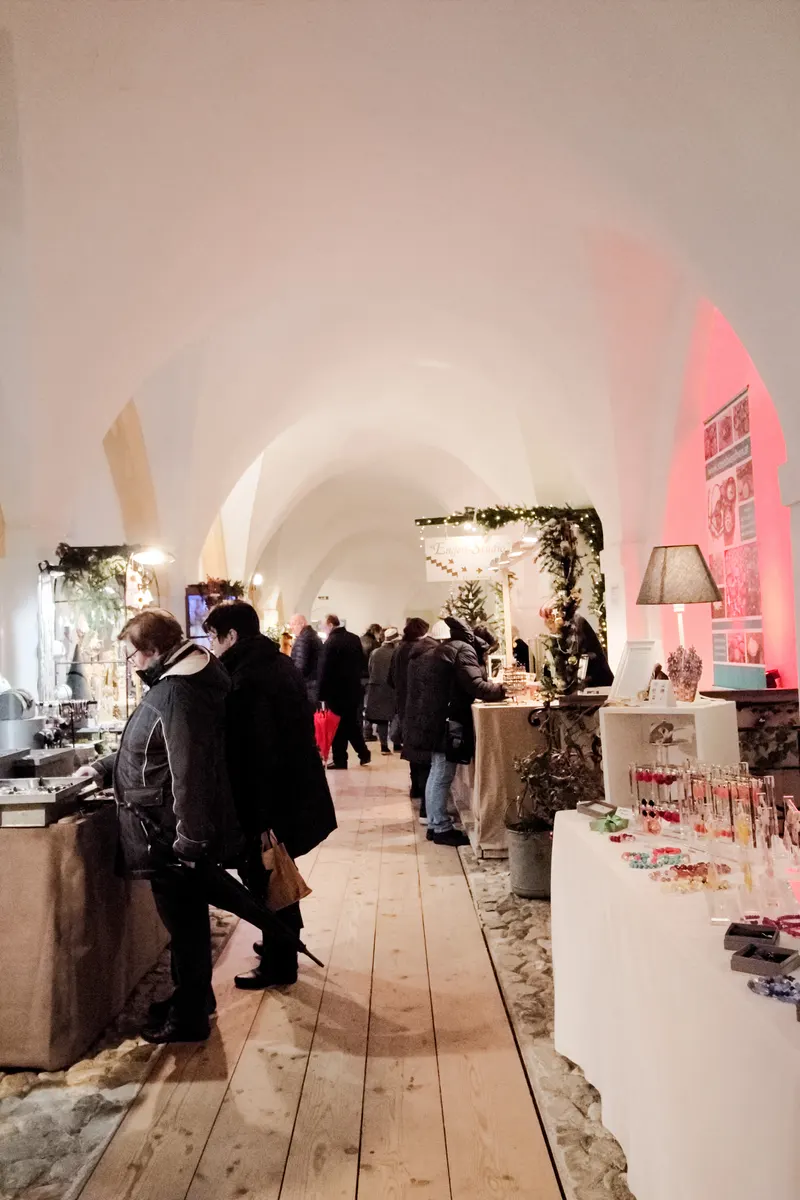 Besucher an den Ständen im Gewölbe des Klosters Mondsee beim Advent in Mondsee