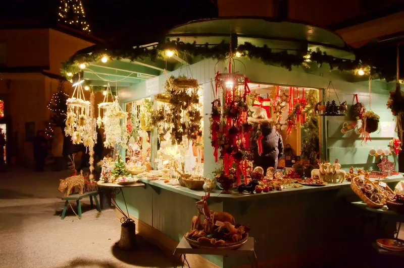 Weihnachtlich geschmückter Marktstand beim Hellbrunner Adventzauber am Abend