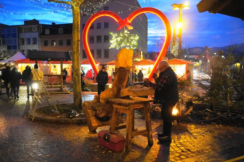 Holzschnitzer vor einem leuchtenden Herz am Villacher Advent