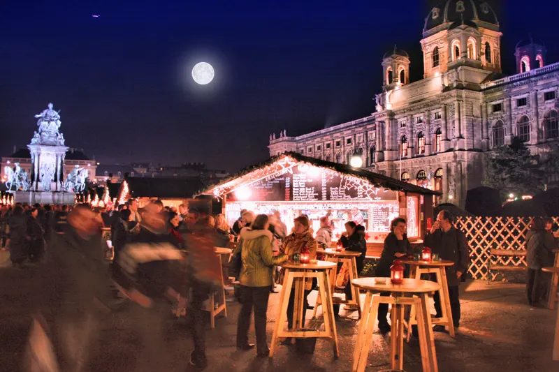 Beleuchteter Markt im Weihnachtsdorf am Maria-Theresien-Platz bei Nacht