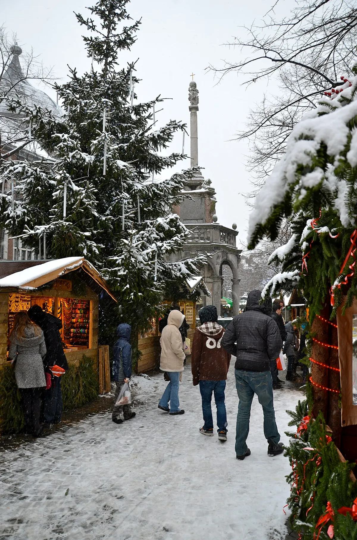 Chalets enneigés du Village de Noël de Liège sous les sapins