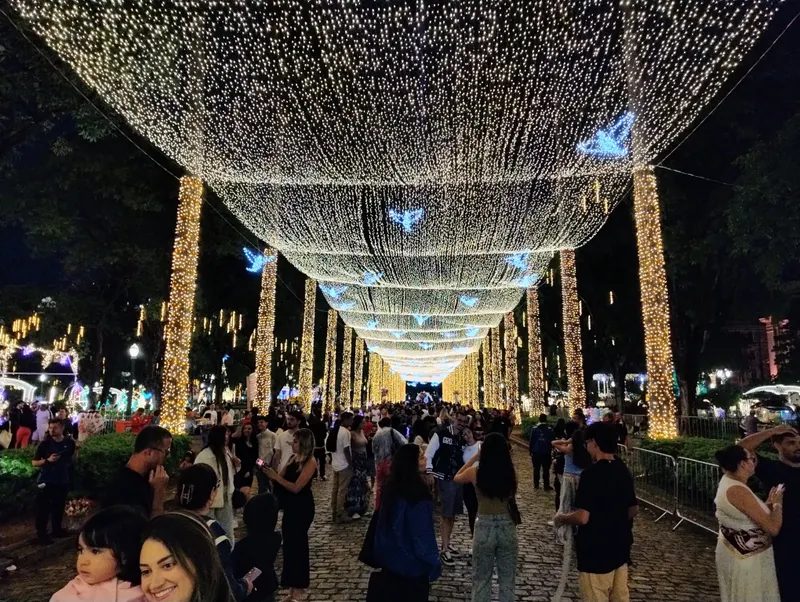 Visitantes sob o teto de luzes na Praça da Liberdade no Natal, em Belo Horizonte