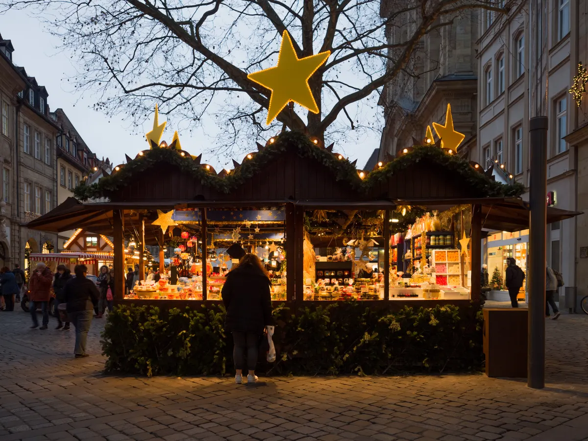 Weihnachtsmarktbuden mit Sternen in der Bamberger Innenstadt am Abend