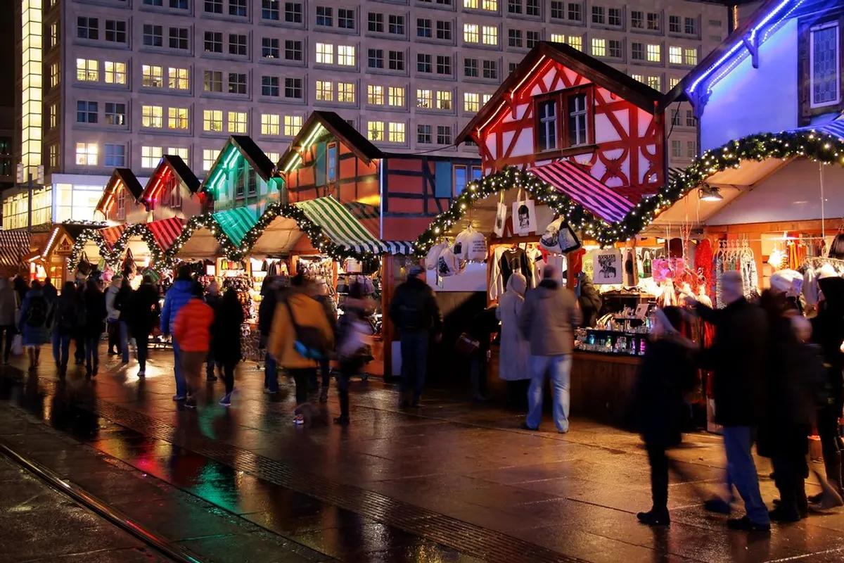 Weihnachtsmarkt am Alexanderplatz in Berlin mit bunten Fachwerk-Buden am Abend