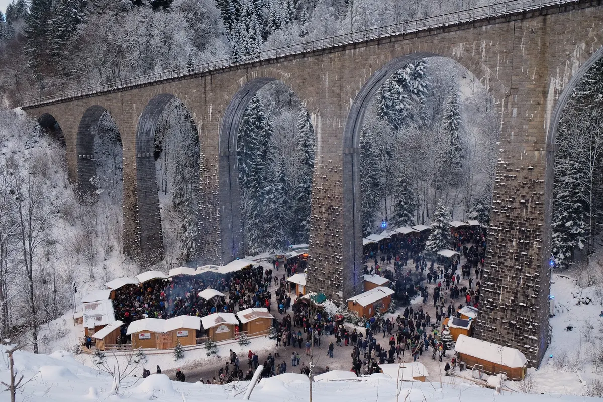 Weihnachtsmarkt unter dem Ravennaviadukt im verschneiten Schwarzwald