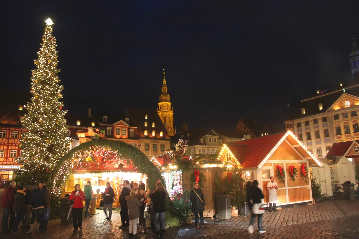 Coburger Marktplatz mit beleuchtetem Weihnachtsbaum und festlichem Torbogen bei Nacht