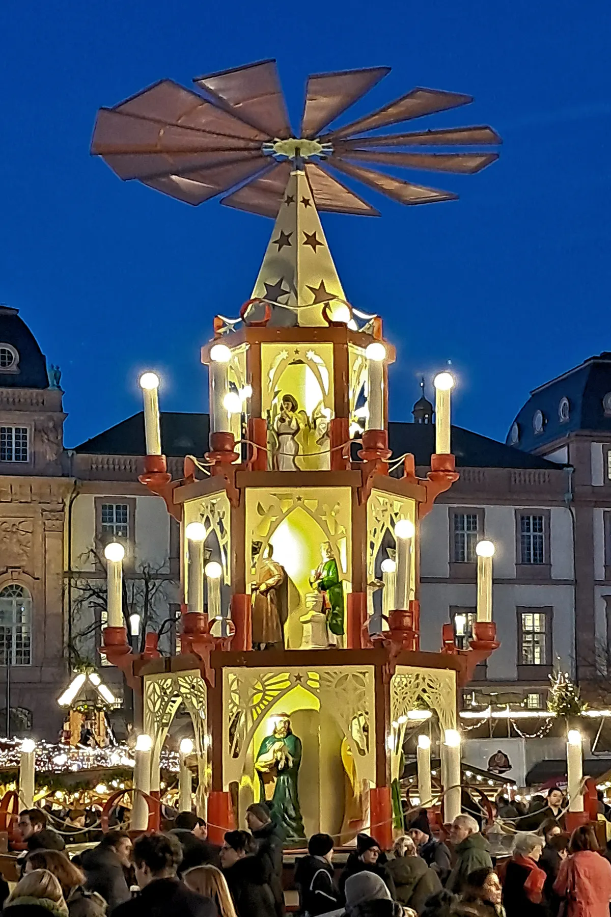 Beleuchtete Weihnachtspyramide mit Krippenfiguren vor dem Darmstädter Schloss in der Abenddämmerung