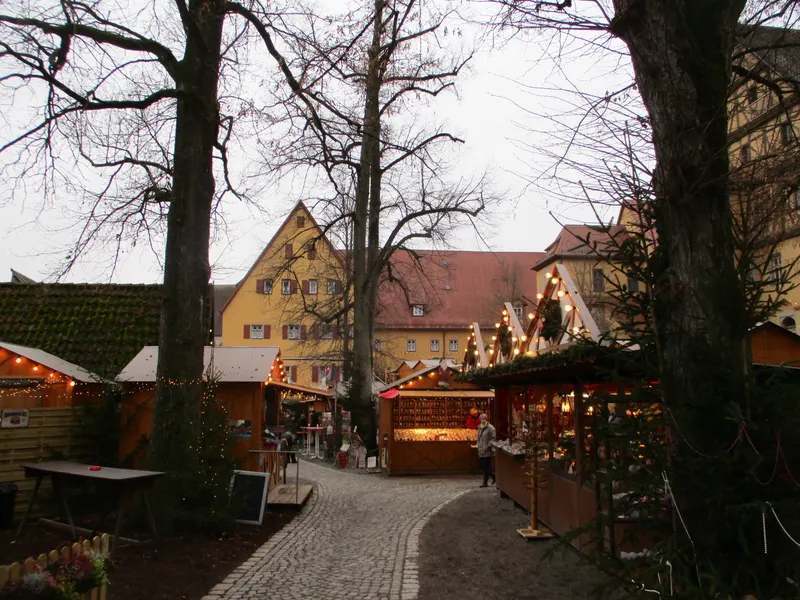 Beleuchtete Hütten zwischen den Bäumen des Dinkelsbühler Weihnachtsmarkts