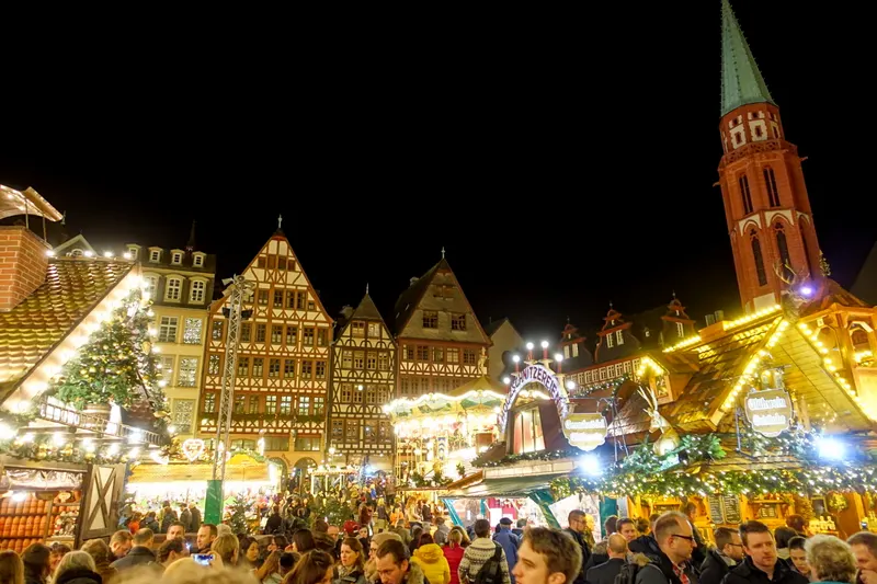 Weihnachtsmarkt Frankfurt am Römerberg mit Besuchern und Nikolaikirche
