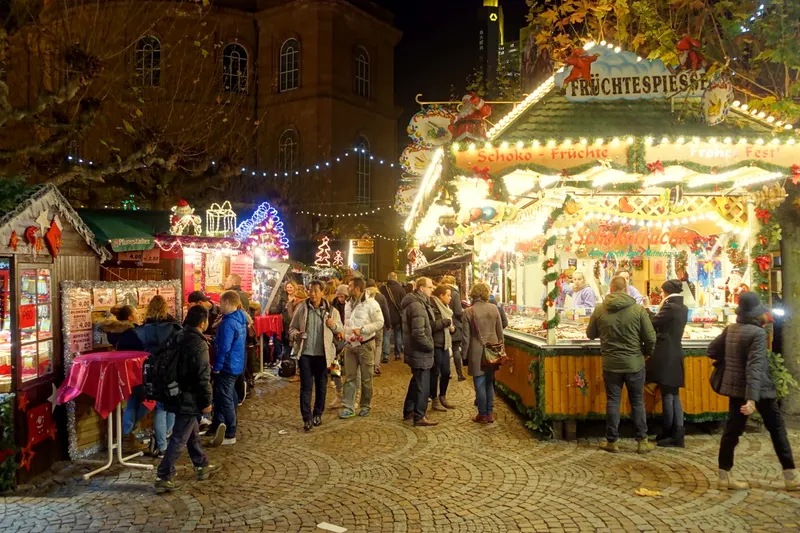 Besucher an beleuchteten Ständen auf dem Frankfurter Weihnachtsmarkt