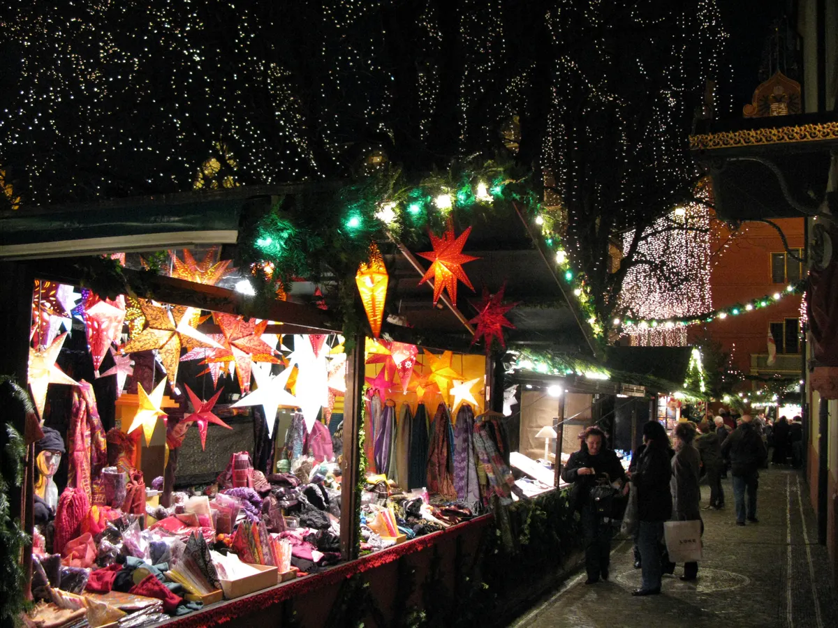 Stand mit Papiersternen und Laternen auf dem Freiburger Weihnachtsmarkt am Abend