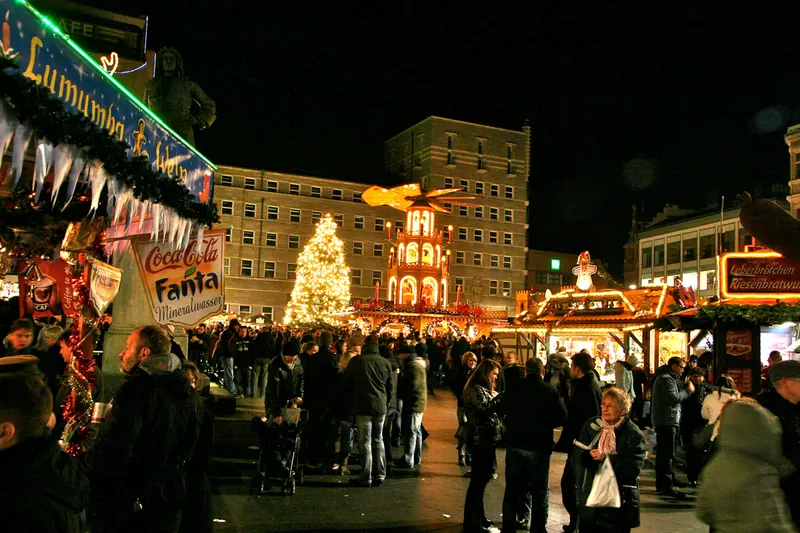 Pyramide und Besucher auf dem Hallenser Weihnachtsmarkt bei Nacht
