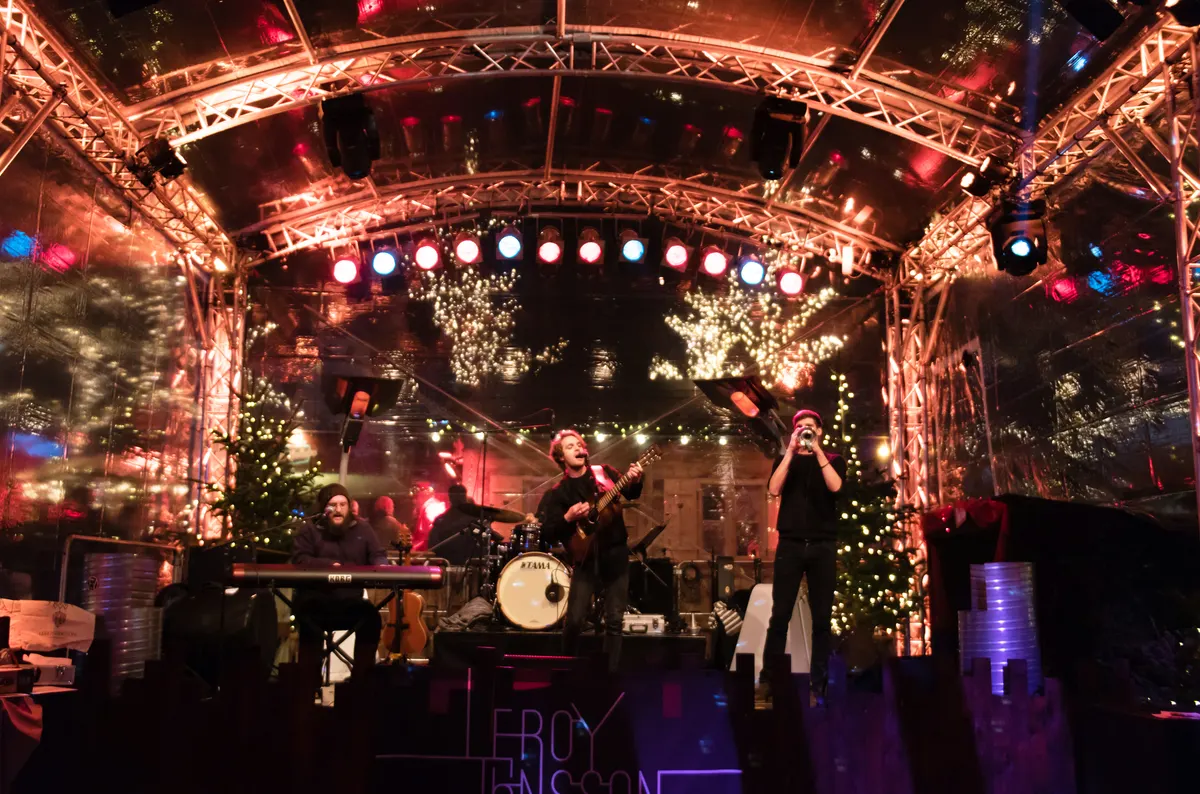 Bühne auf dem Santa Pauli Weihnachtsmarkt in Hamburg mit Lichtern und Tannenbäumen