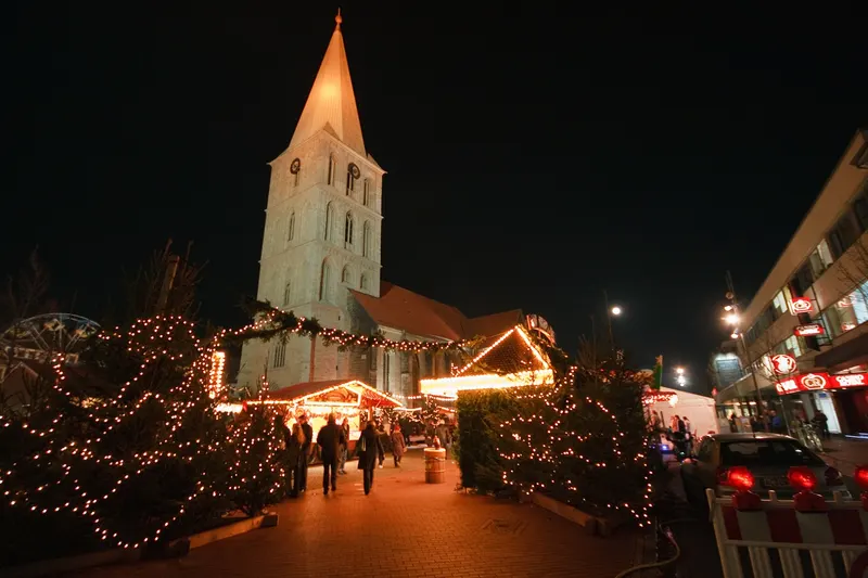 Beleuchtete Kirche und Weihnachtsmarktbuden in Hamm bei Nacht