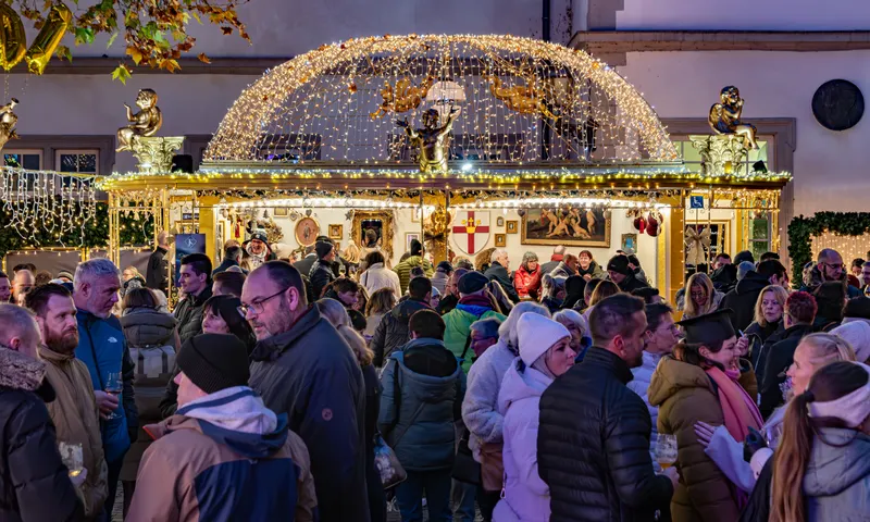Gedränge vor einem beleuchteten Marktstand in Koblenz