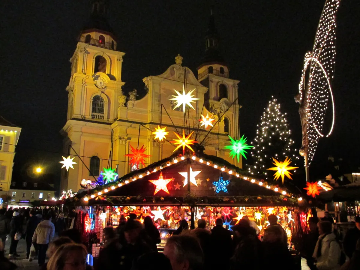 Barock-Weihnachtsmarkt Ludwigsburg mit leuchtenden Sternen und angestrahlter Stadtkirche
