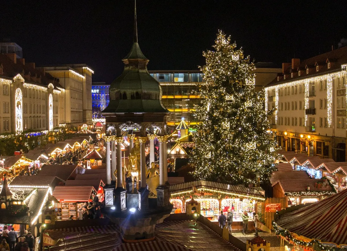 Magdeburger Weihnachtsmarkt bei Nacht mit großem Weihnachtsbaum und Johanniskirche