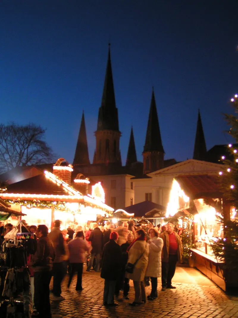 Lamberti-Kirche und Weihnachtsmarktbuden in Oldenburg am Abend