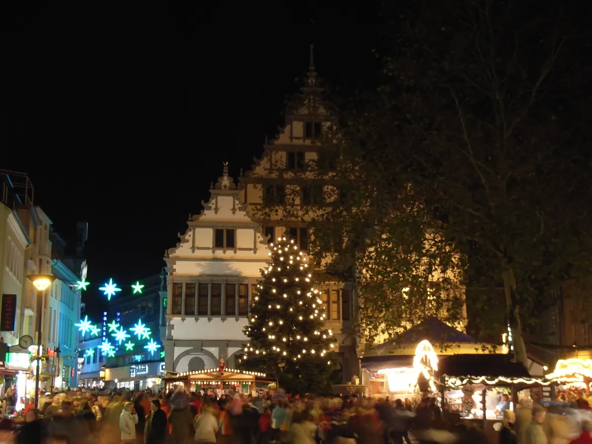 Paderborner Weihnachtsmarkt am Rathaus bei Nacht mit Tannenbaum