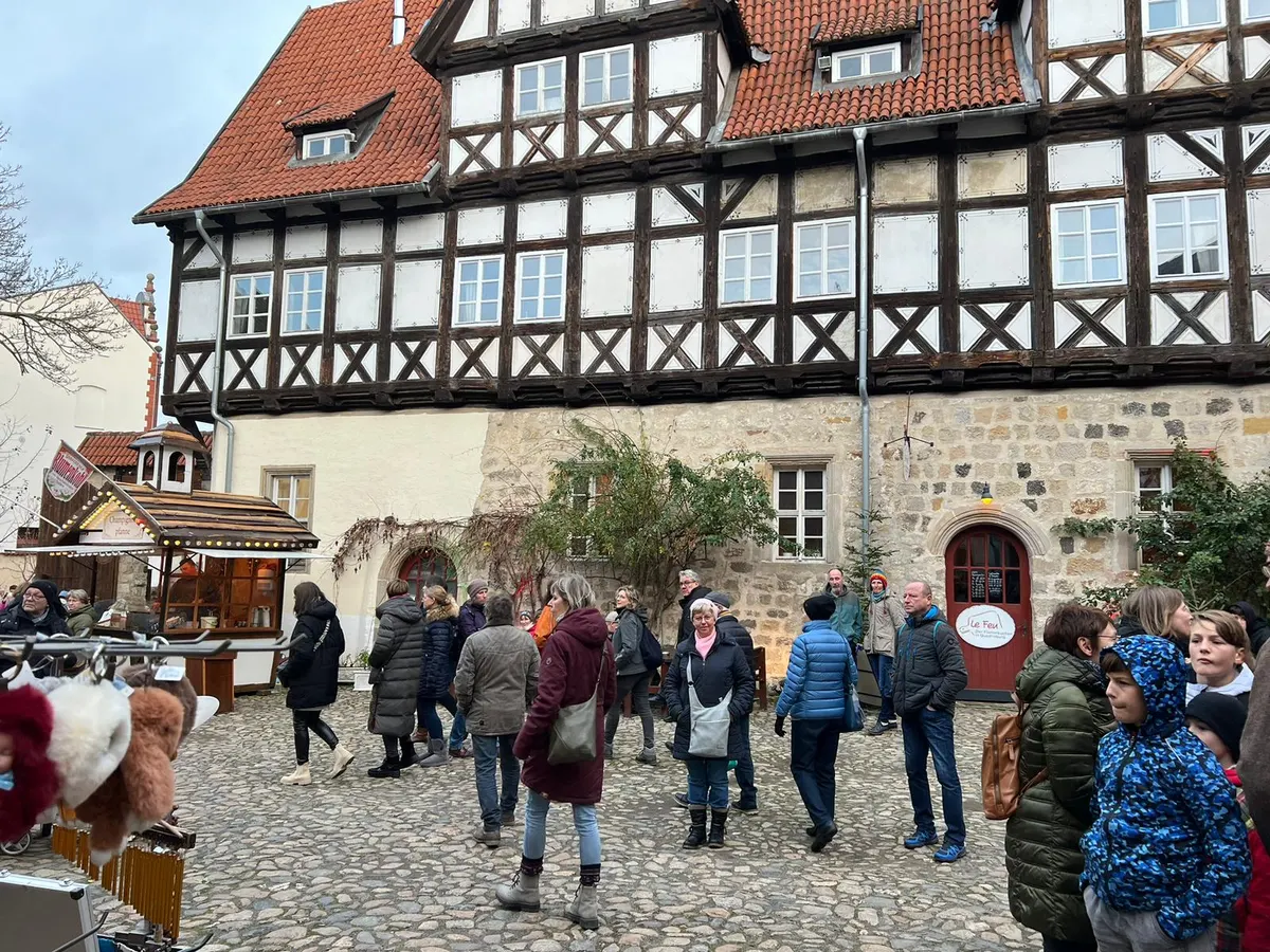 Besucher im Hof zwischen Fachwerkhäusern beim Advent in den Höfen in Quedlinburg