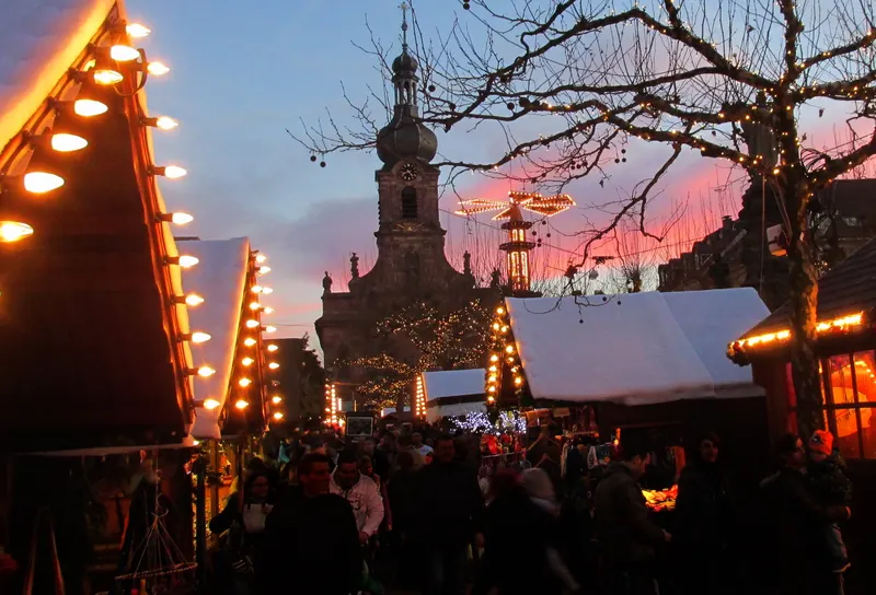 Beleuchtete Hütten auf dem Rastatter Weihnachtsmarkt in der Dämmerung
