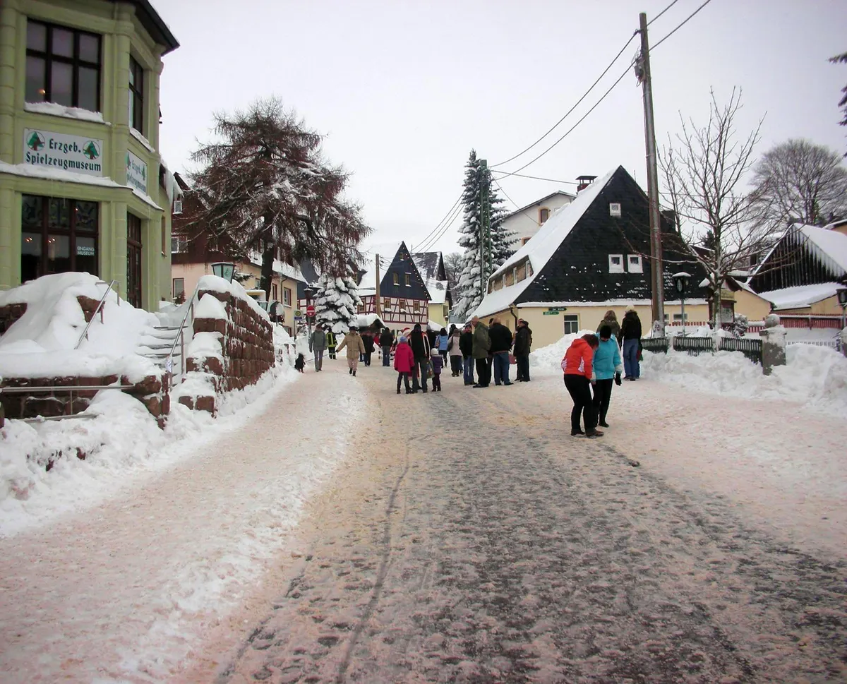 Verschneite Straße in Seiffen im Erzgebirge mit Besuchern