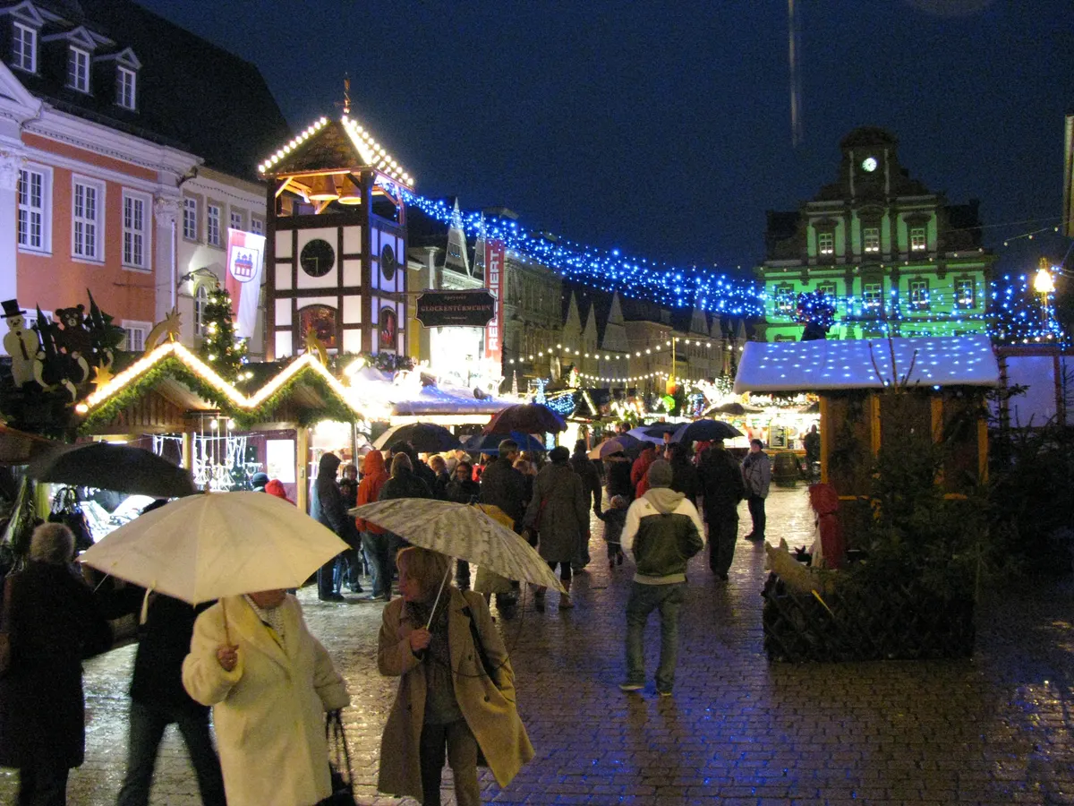 Speyerer Weihnachtsmarkt im Regen mit blau beleuchteten Hütten