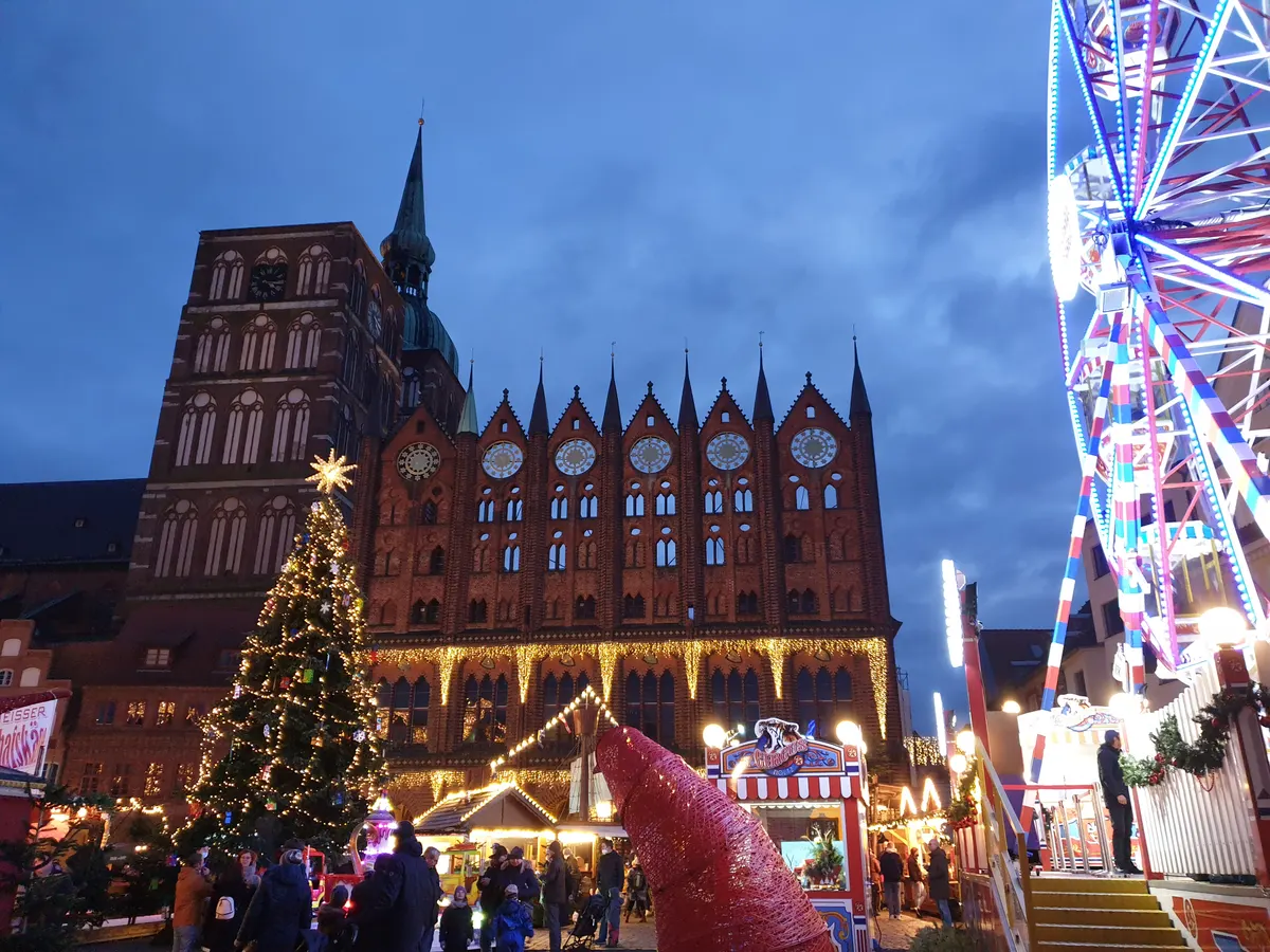 Stralsunder Rathaus im Abendlicht mit Weihnachtsbaum und Riesenrad