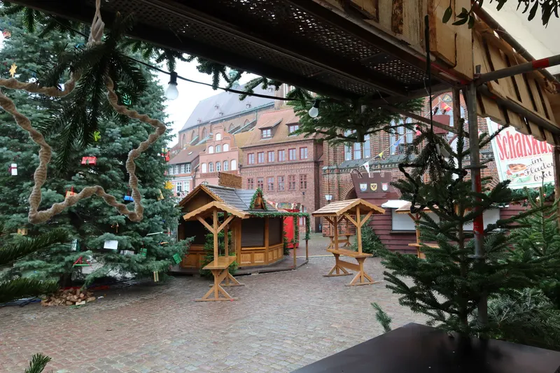 Hütten zwischen Tannen auf dem Stralsunder Weihnachtsmarkt