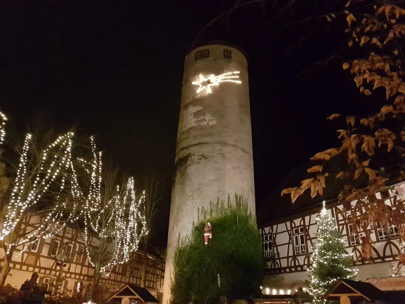 Turm mit Leuchtstern und Lichterketten-Bäumen beim Weihnachtsmarkt Tauberbischofsheim