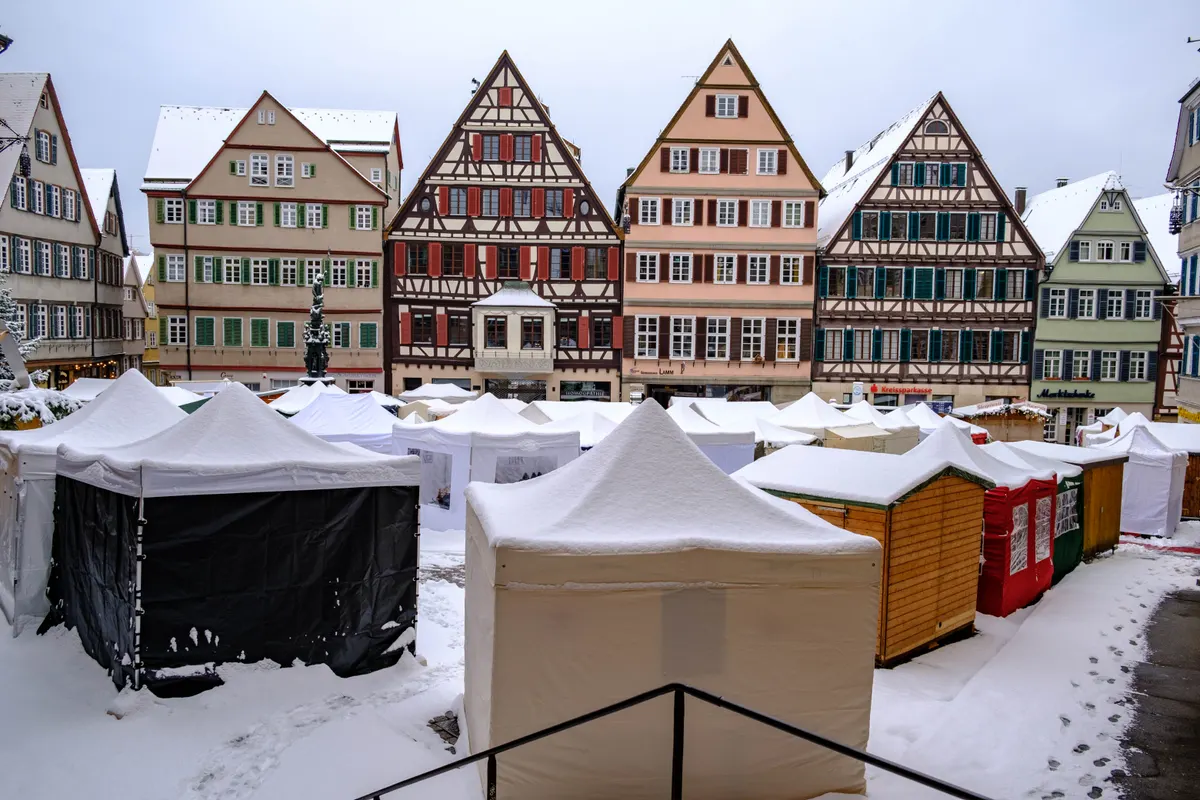 Verschneiter Tübinger Weihnachtsmarkt auf dem Marktplatz vor Fachwerkhäusern