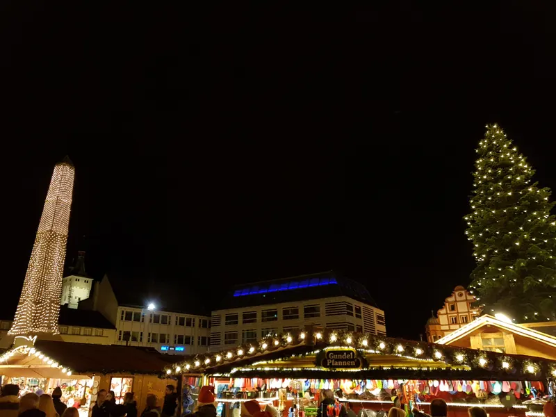 Lichterpyramide und Marktbuden in Würzburg am Abend