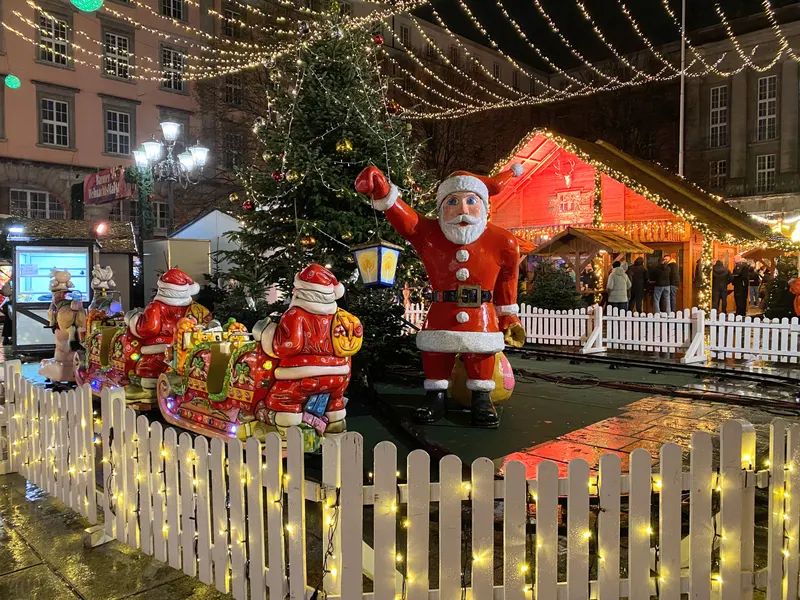 Weihnachtsmänner und Zaun mit Lichterkette auf dem Barmer Weihnachtsmarkt