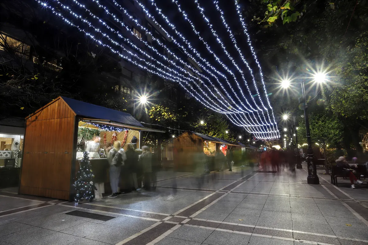 Casetas del mercado de Navidad de Gijón bajo las luces del paseo