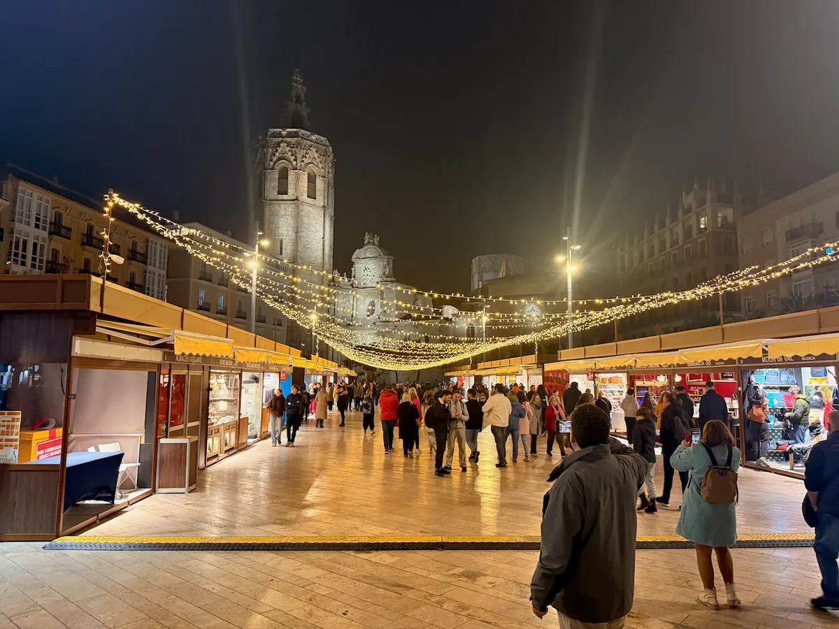 Mercado artesanal de Navidad en la Plaza de la Reina de Valencia con el Miguelete al fondo